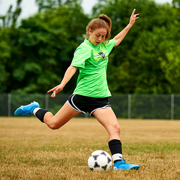 female soccer player winding up to kick ball
